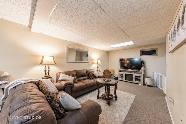 carpeted living room with radiator heating unit and a drop ceiling