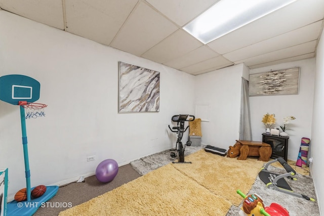 exercise room featuring carpet flooring and a paneled ceiling