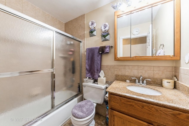 full bathroom featuring bath / shower combo with glass door, vanity, and toilet