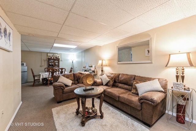 living room featuring carpet and a paneled ceiling