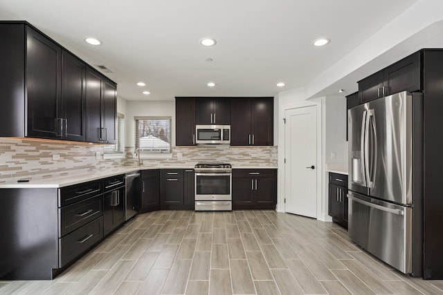 kitchen featuring appliances with stainless steel finishes, sink, and decorative backsplash