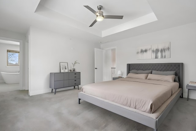 carpeted bedroom with ceiling fan and a raised ceiling