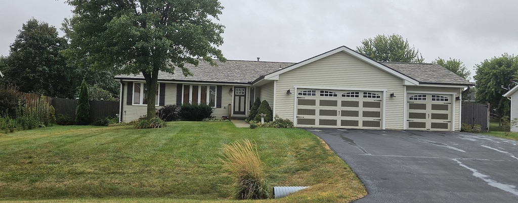 ranch-style home featuring a garage and a front yard