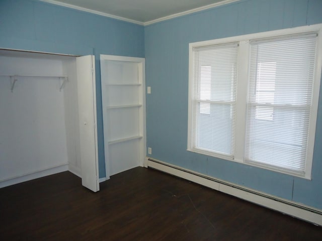 unfurnished bedroom with a closet, dark hardwood / wood-style flooring, crown molding, and a baseboard radiator