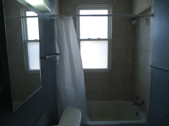 bathroom with shower / bath combo with shower curtain and toilet