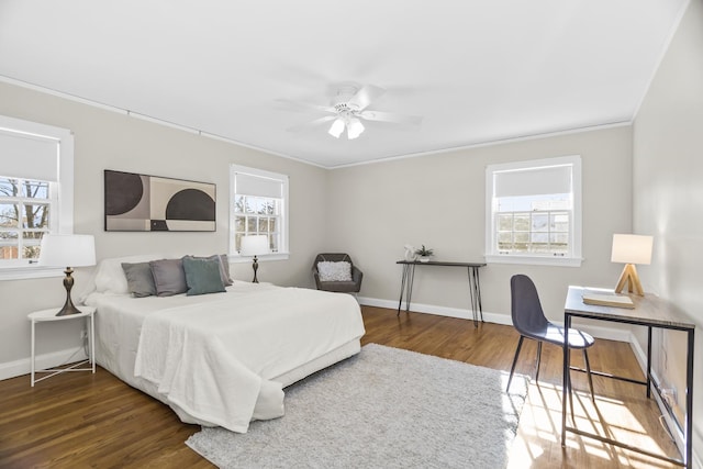 bedroom featuring crown molding, ceiling fan, dark hardwood / wood-style flooring, and multiple windows