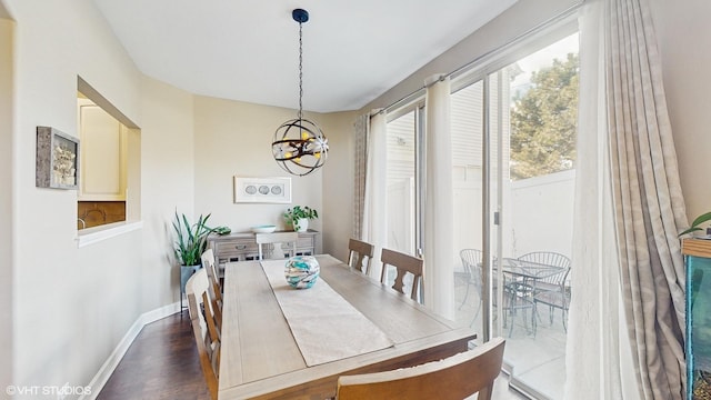 dining area with dark wood-type flooring and a chandelier