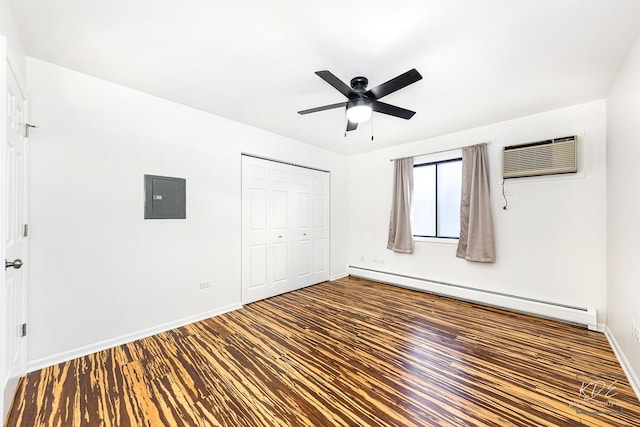 unfurnished bedroom featuring baseboard heating, dark wood-type flooring, a closet, ceiling fan, and electric panel