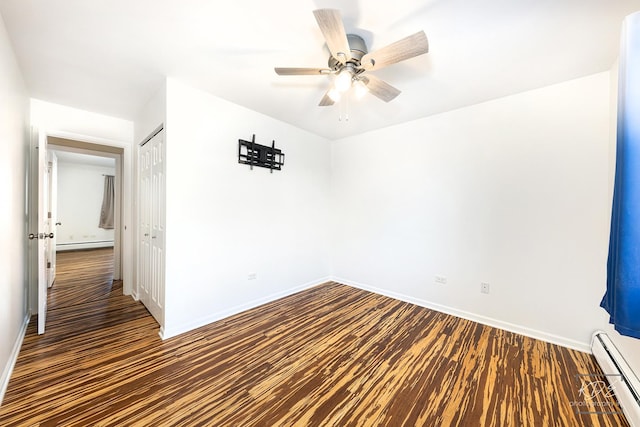 unfurnished room featuring ceiling fan, dark hardwood / wood-style floors, and baseboard heating