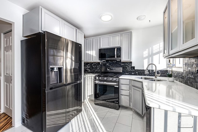 kitchen featuring sink, stainless steel appliances, backsplash, and gray cabinets