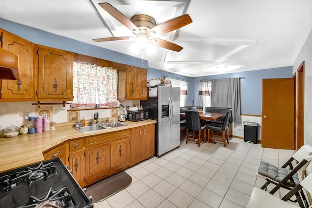 kitchen featuring black appliances, light tile patterned floors, ceiling fan, and sink