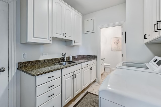 laundry area with sink, washer and dryer, cabinets, and light tile patterned flooring