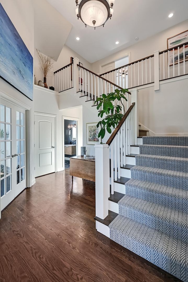 foyer entrance with french doors, a high ceiling, and dark wood-type flooring