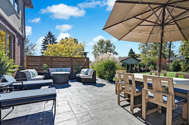 view of patio with an outdoor living space with a fire pit