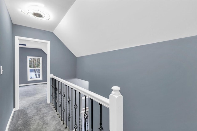 corridor with carpet and vaulted ceiling