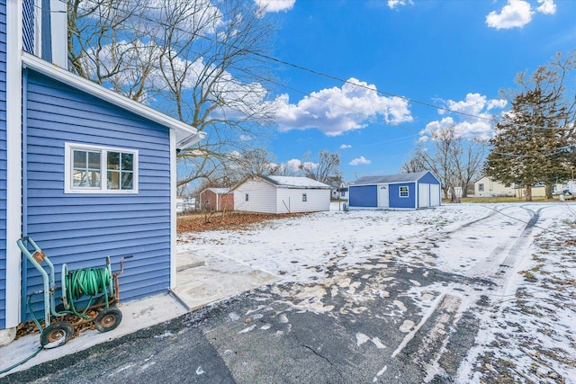 yard covered in snow featuring a storage unit