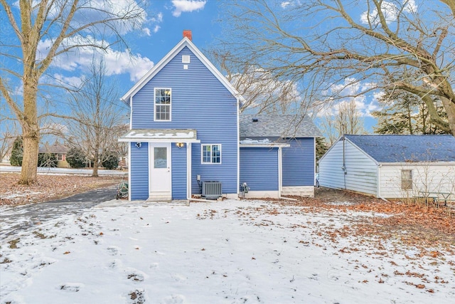 snow covered house with central AC unit