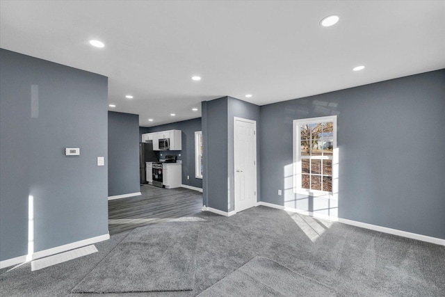 unfurnished living room with dark colored carpet