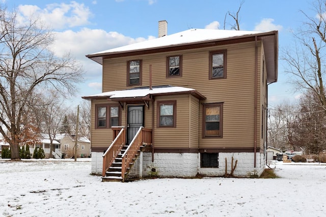 view of snow covered back of property