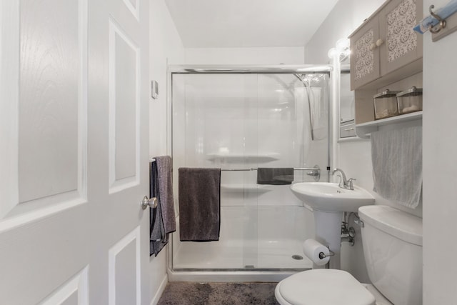 bathroom with a shower with shower door and toilet