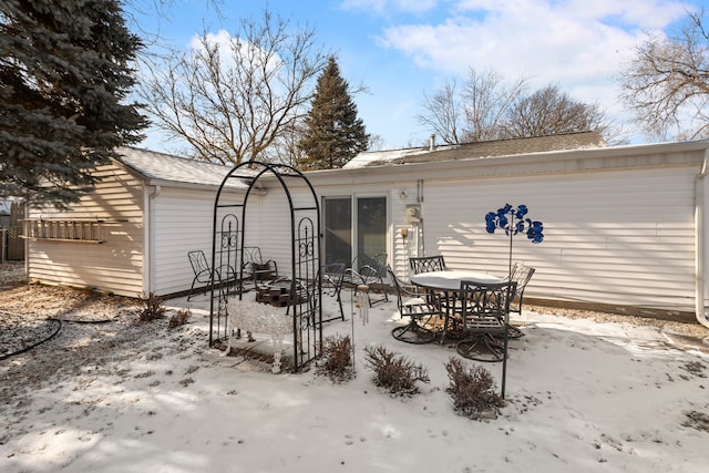 snow covered house with an outdoor fire pit