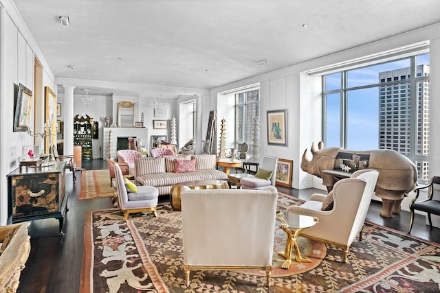 living room featuring ornate columns, plenty of natural light, and dark hardwood / wood-style floors