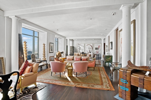 interior space featuring hardwood / wood-style flooring, crown molding, and ornate columns