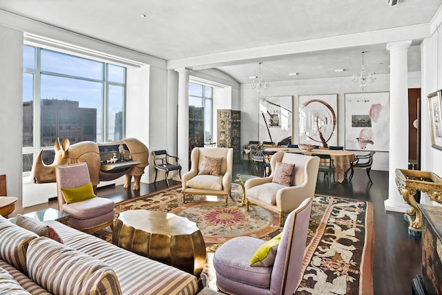 living room with decorative columns, wood-type flooring, and a chandelier