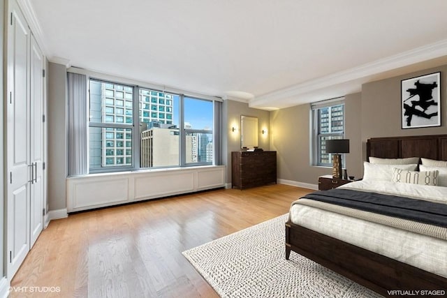 bedroom featuring ornamental molding, a closet, and light hardwood / wood-style flooring