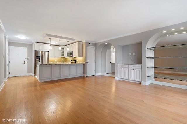 unfurnished living room with crown molding and light wood-type flooring