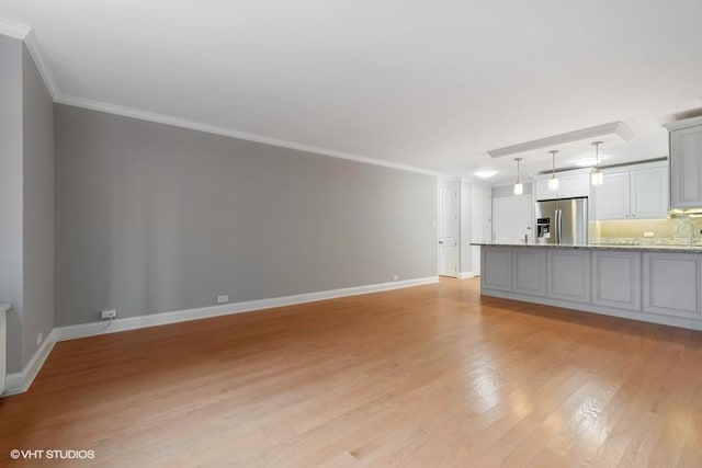 unfurnished living room with crown molding and light hardwood / wood-style floors