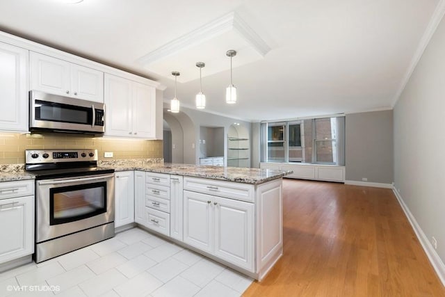 kitchen with kitchen peninsula, white cabinets, and appliances with stainless steel finishes