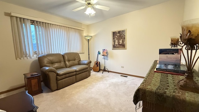 living area featuring carpet, visible vents, baseboards, and a ceiling fan