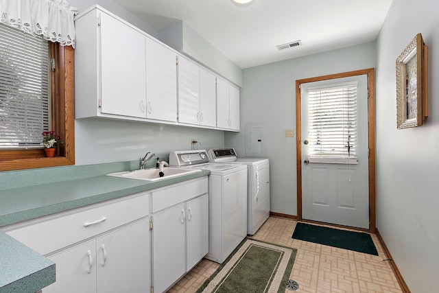 washroom featuring separate washer and dryer, a sink, visible vents, baseboards, and cabinet space