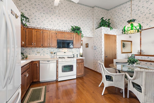 kitchen with brown cabinetry, white appliances, and light countertops