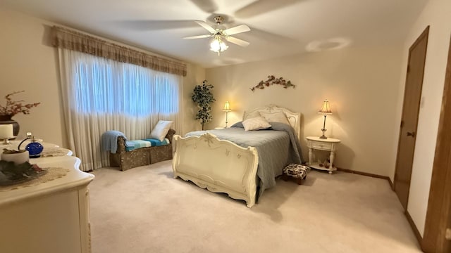 bedroom featuring ceiling fan, baseboards, and light colored carpet