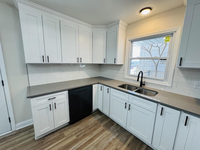 kitchen featuring black dishwasher, backsplash, dark wood-type flooring, white cabinets, and sink