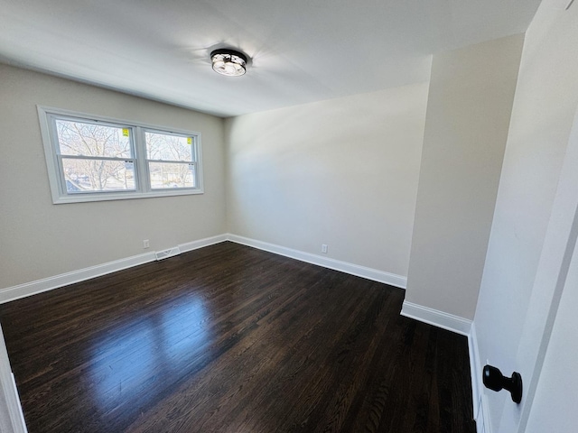 unfurnished room with dark hardwood / wood-style flooring