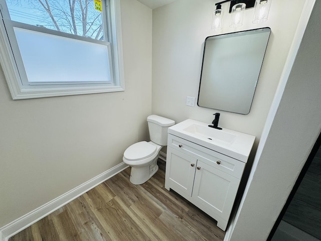 bathroom with hardwood / wood-style floors, toilet, and vanity