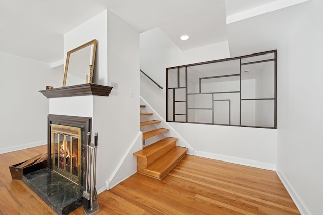 staircase featuring hardwood / wood-style flooring and a multi sided fireplace