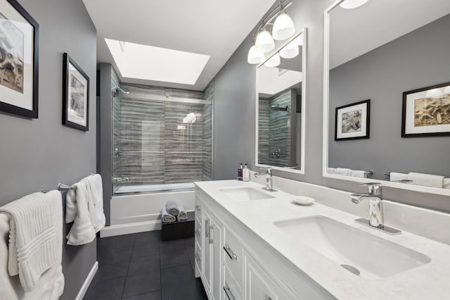 bathroom with tile patterned floors, shower / bath combination with glass door, a skylight, and vanity