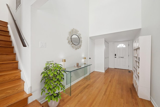 foyer with a high ceiling and light wood-type flooring