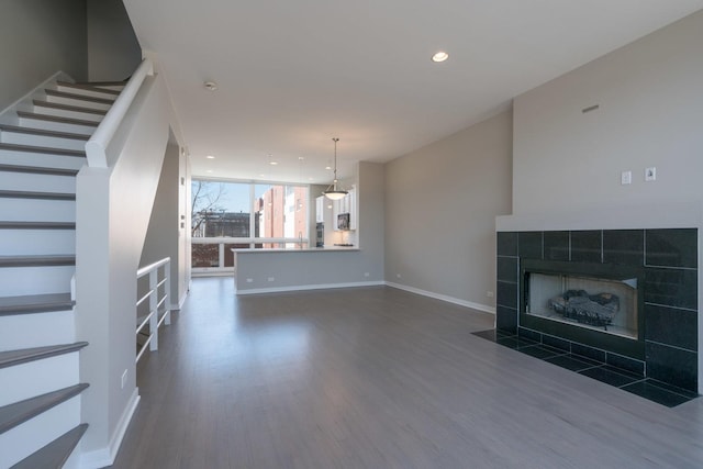 unfurnished living room featuring dark wood-type flooring and a fireplace