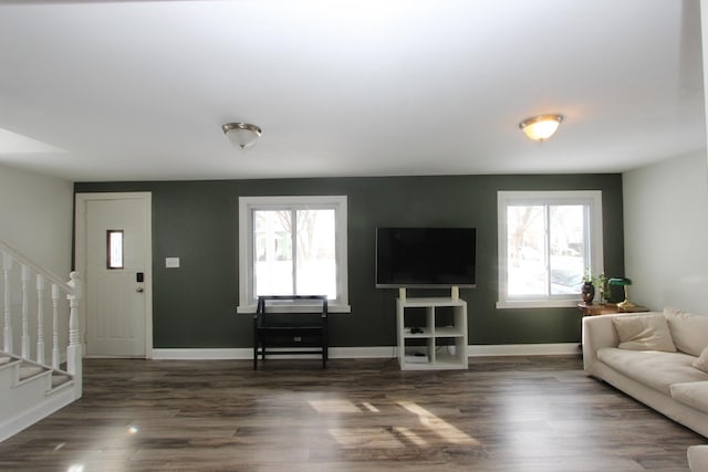 living room featuring a healthy amount of sunlight and dark wood-type flooring