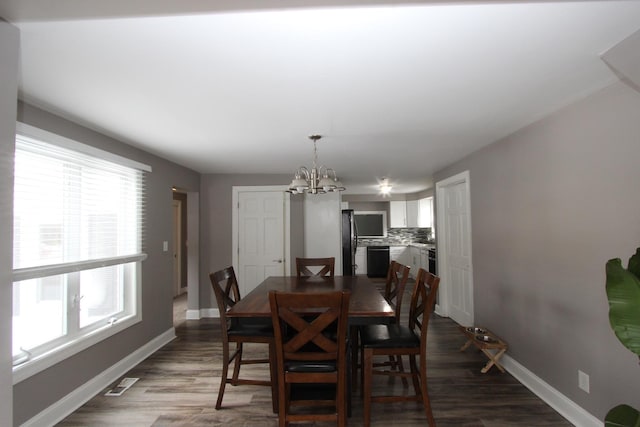 dining area featuring dark hardwood / wood-style floors and a chandelier