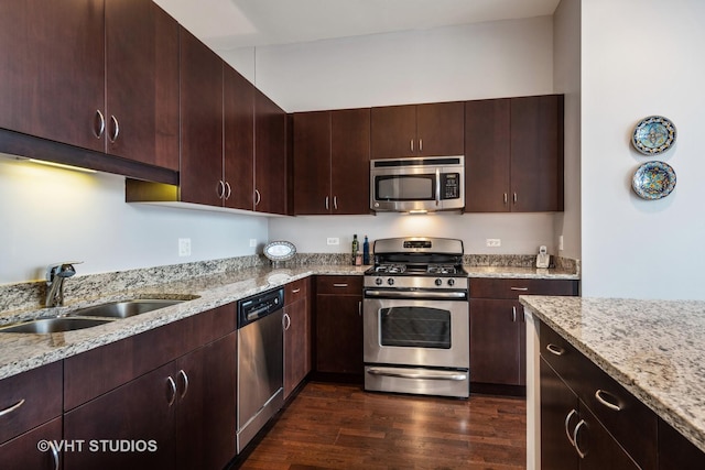 kitchen with sink, stainless steel appliances, dark hardwood / wood-style floors, light stone counters, and dark brown cabinetry