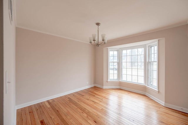 unfurnished room with crown molding, a notable chandelier, and light wood-type flooring