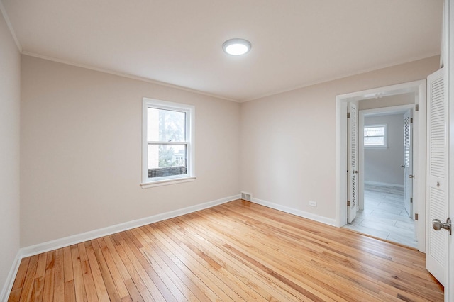 empty room featuring ornamental molding and light hardwood / wood-style floors