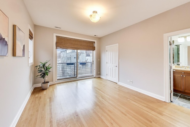 empty room featuring sink and light hardwood / wood-style flooring