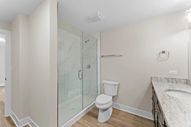 bathroom with a shower with shower door, hardwood / wood-style flooring, toilet, and vanity